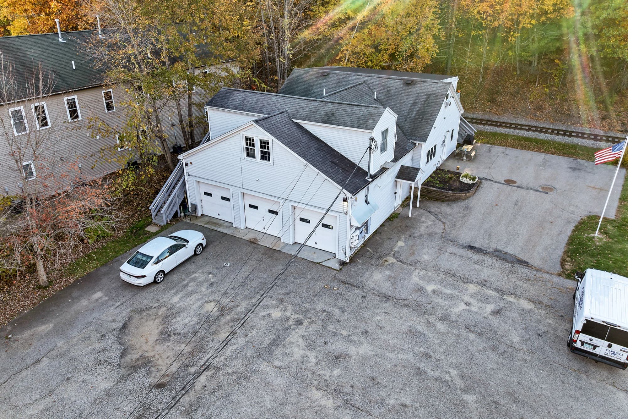The building and the paved lot from the air, with the rail line behind