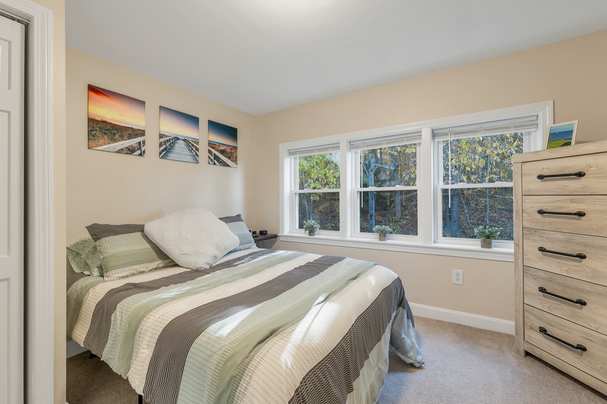 The second bedroom with 3 windows and a dresser