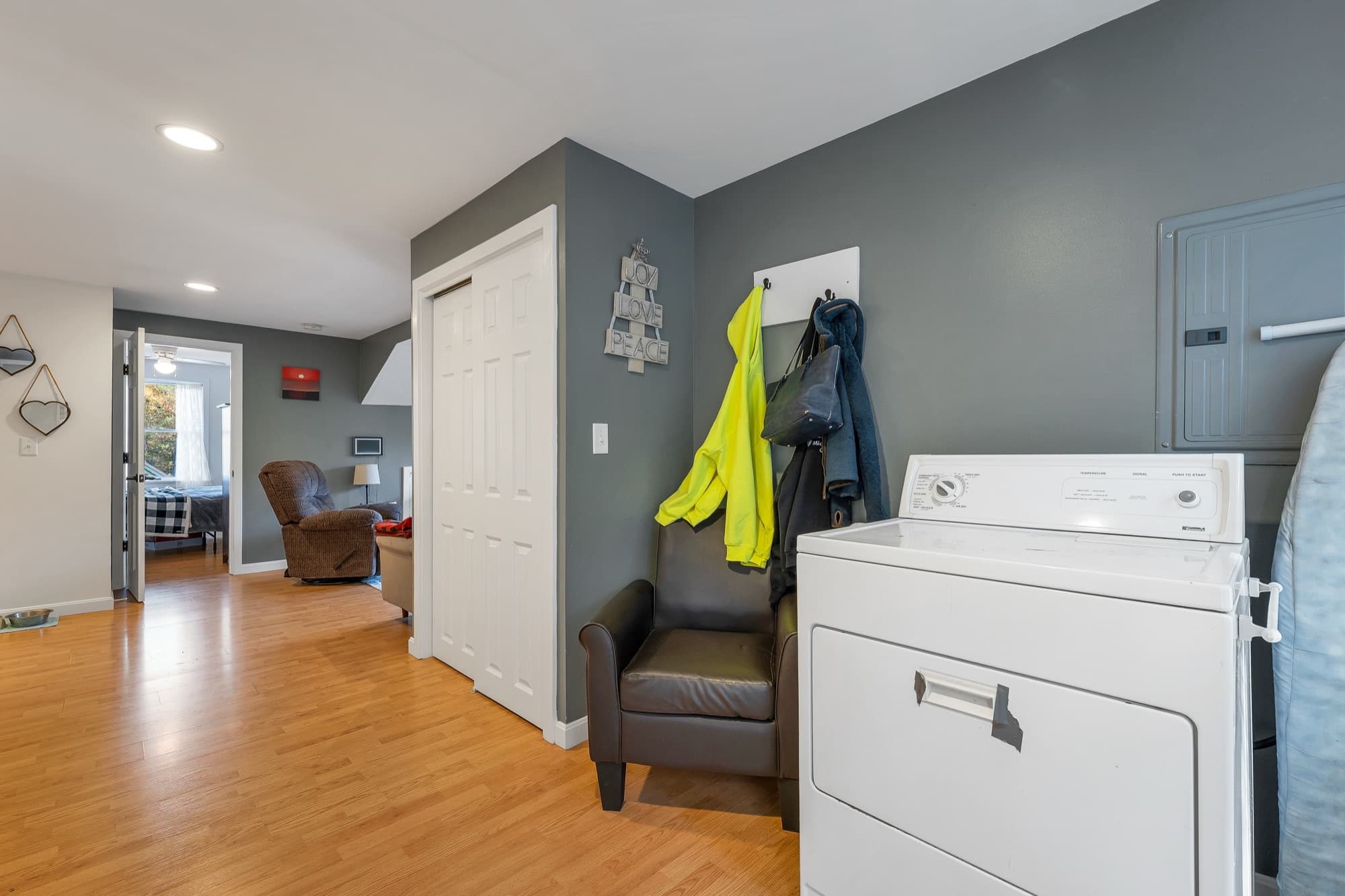 The 1-bedroom apartment's foyer with the washer and dryer, looking into the bedroom