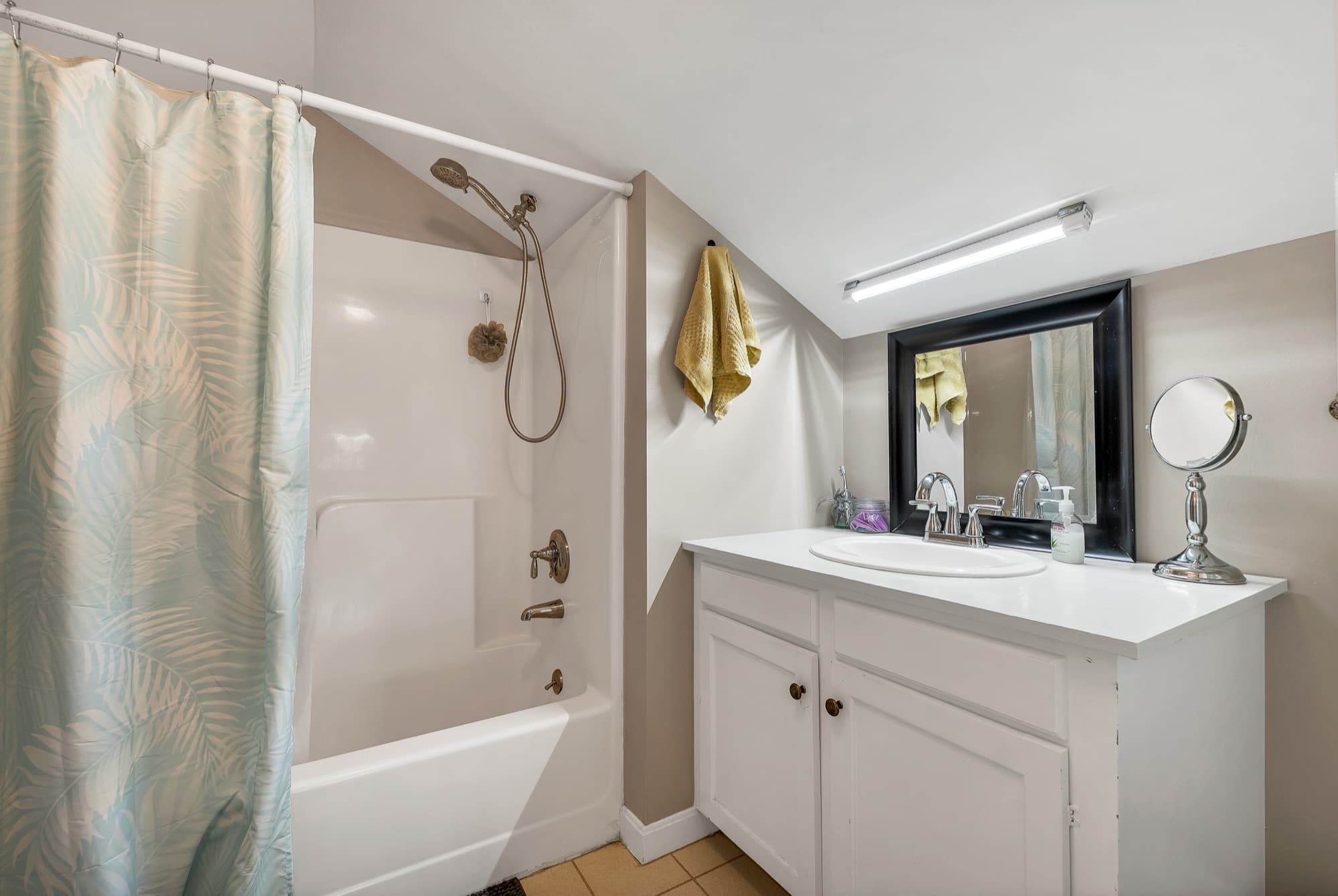 The 1-bedroom apartment's bath with a tub and shower and a vanity