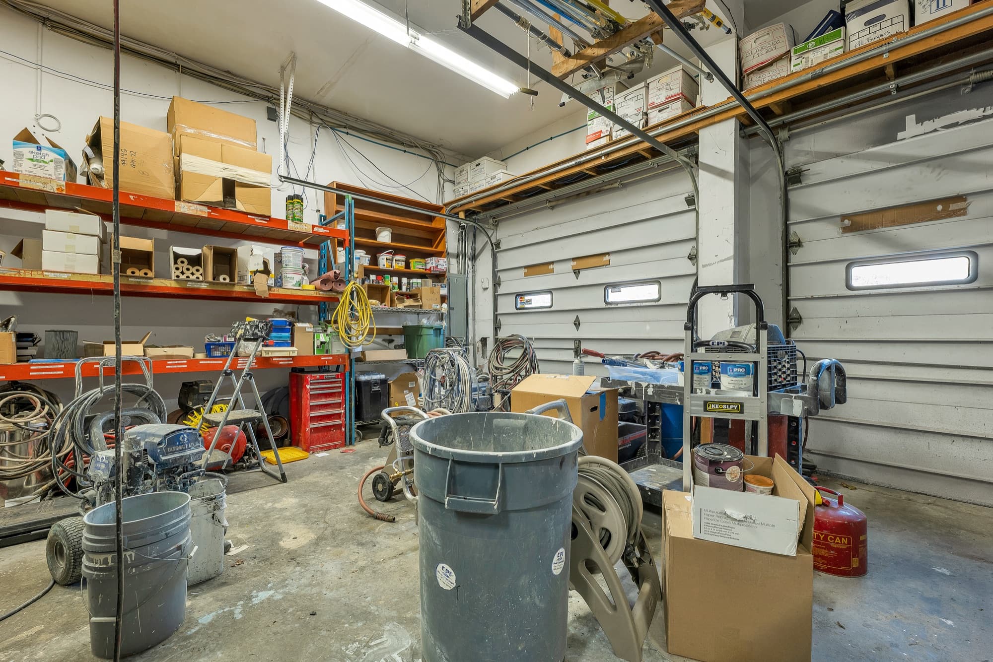 The garage shop with shelving, overhead storage, and the seller's equipment