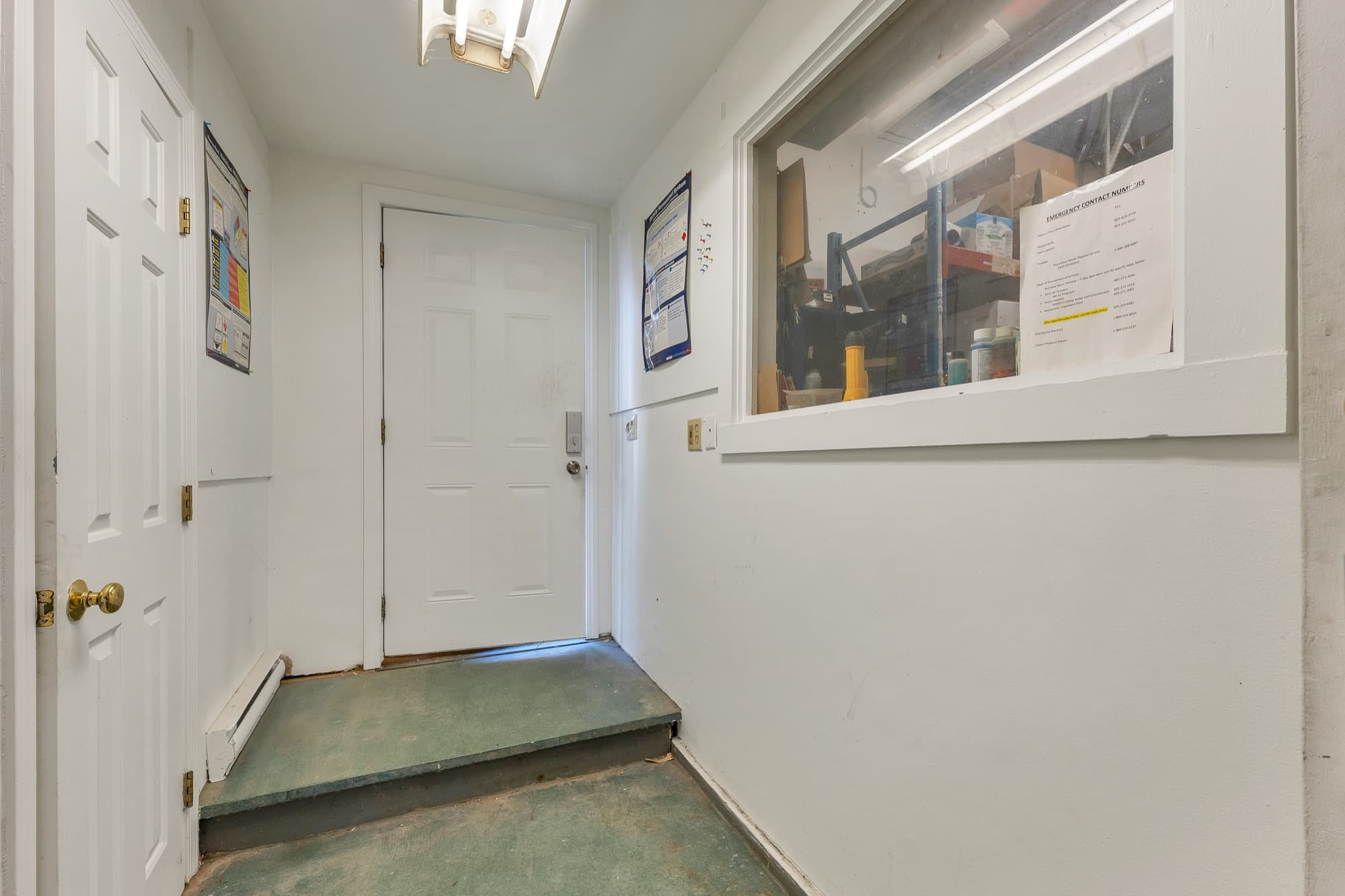 The garage entry hall with a window into the shop and the door to the half bath
